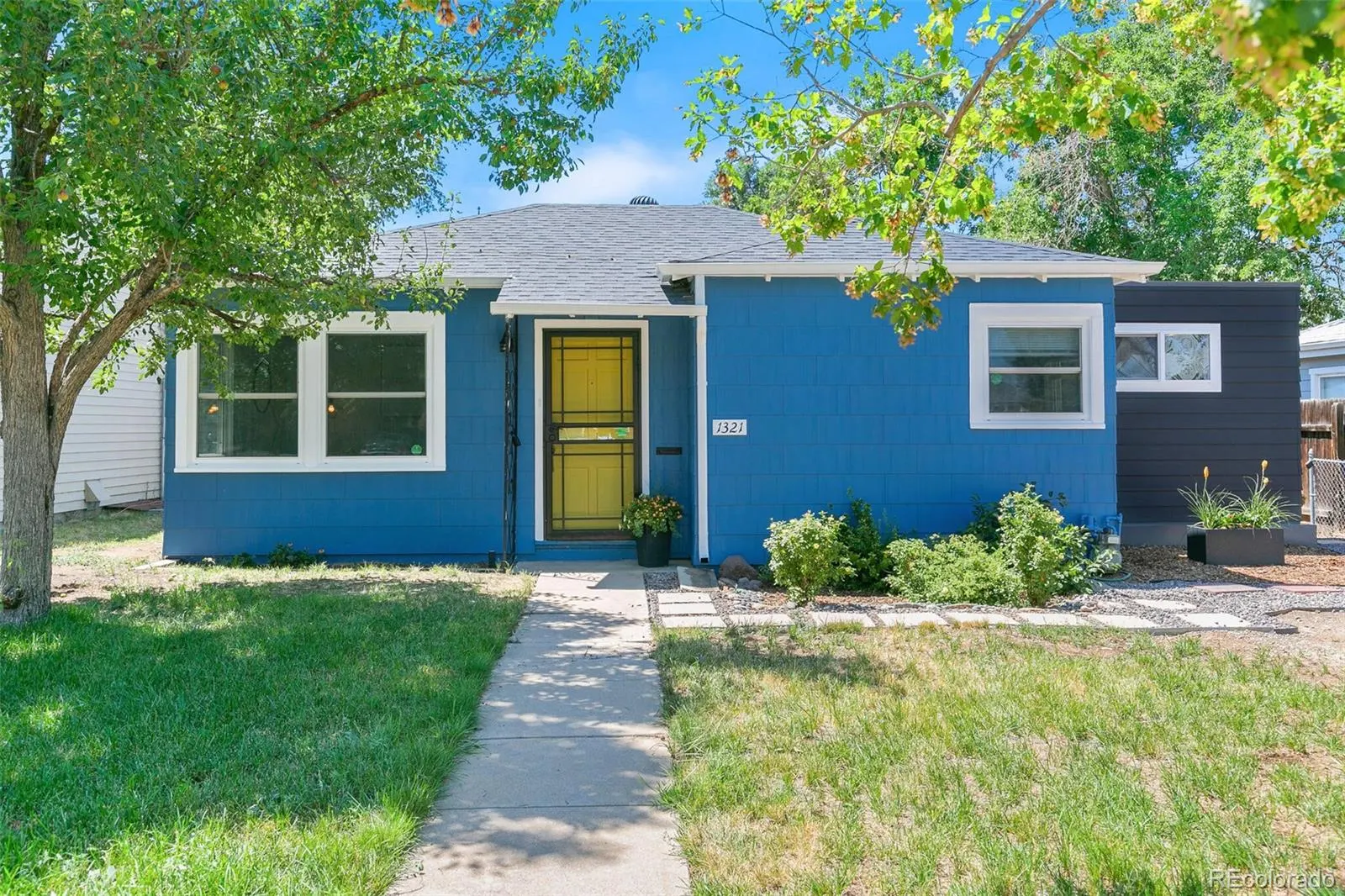 Blue 1942 ranch at 1321 Xanthia Street with yellow door