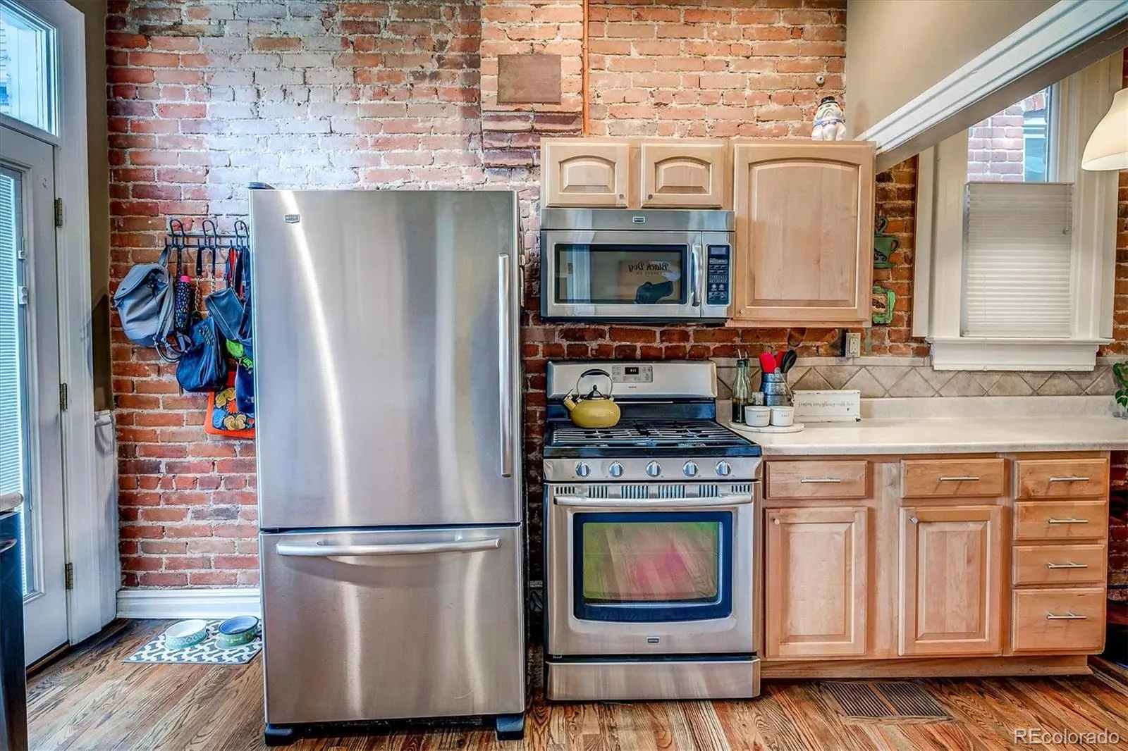 Kitchen with stainless appliances against exposed brick