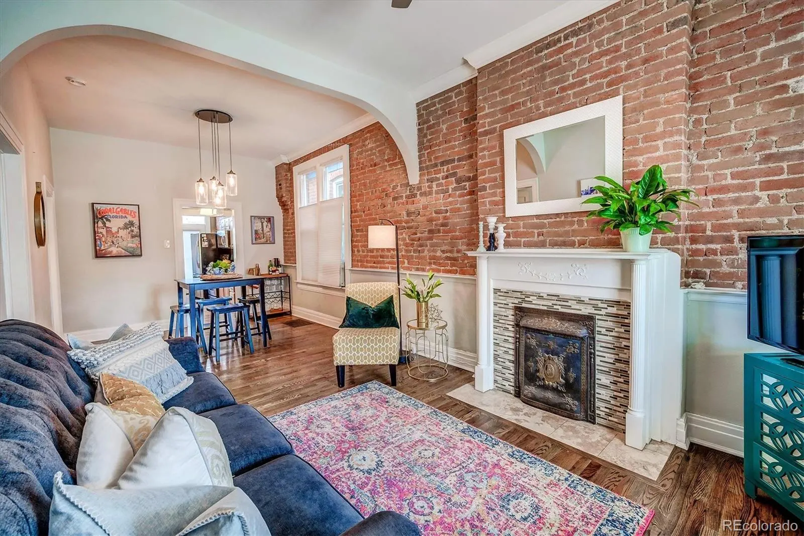 Living room with exposed brick wall and fireplace