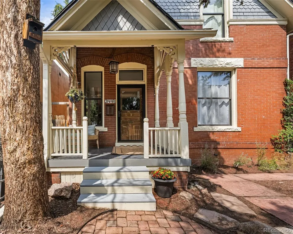 Front porch of the Victorian with white columns and original brickwork