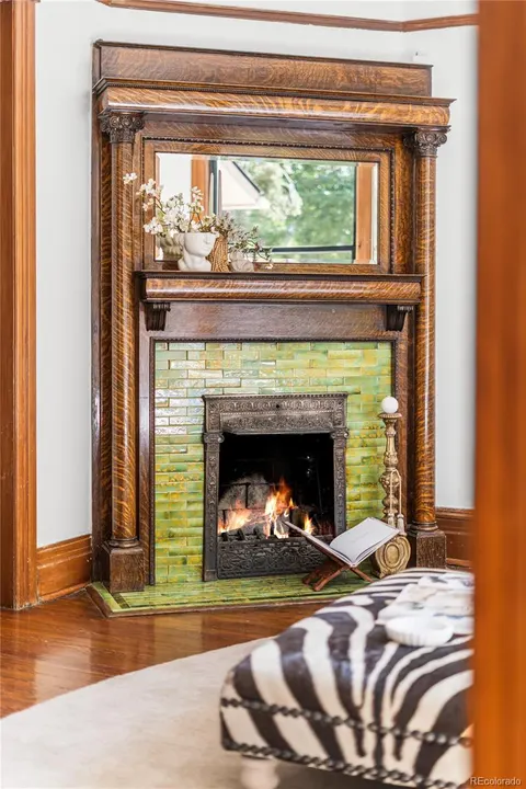 Green-tile fireplace with carved oak mantel