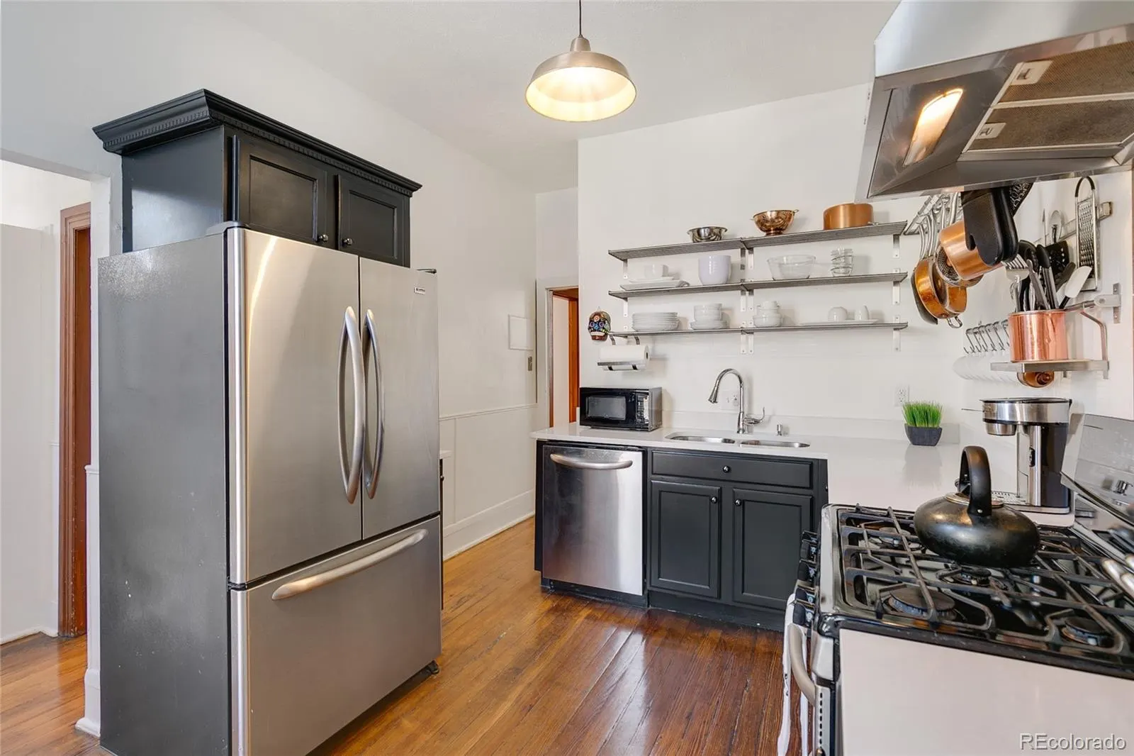 Kitchen with dark cabinetry and white quartz counters
