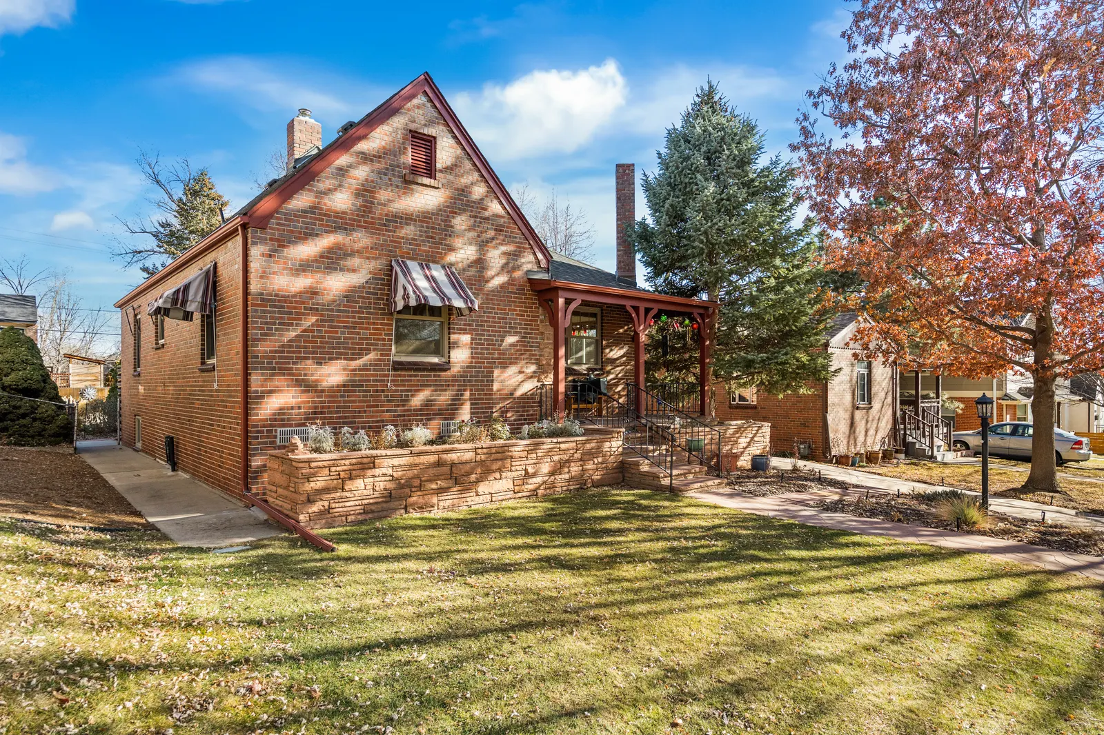 Side view of the brick Tudor in autumn with mature trees