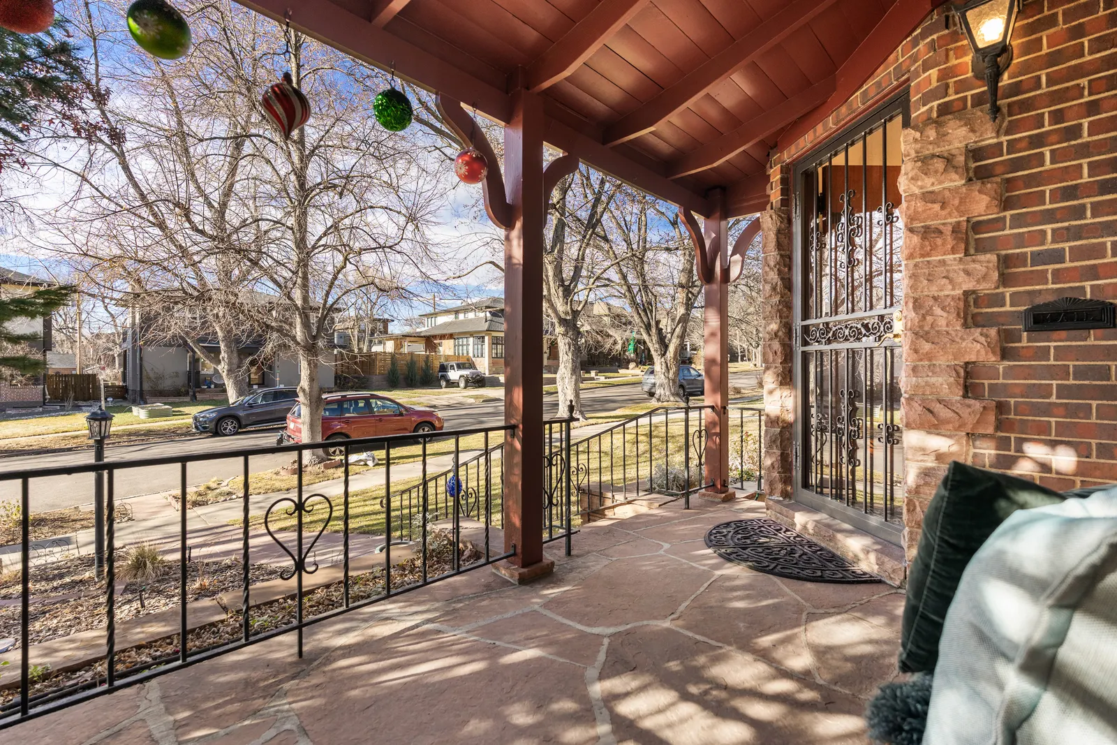 Covered flagstone porch looking toward the tree-lined street