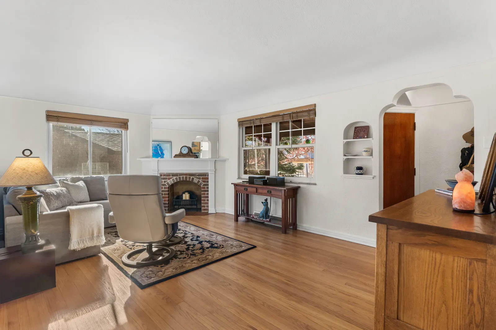Living room with original oak floors, arched doorway and built-in shelving