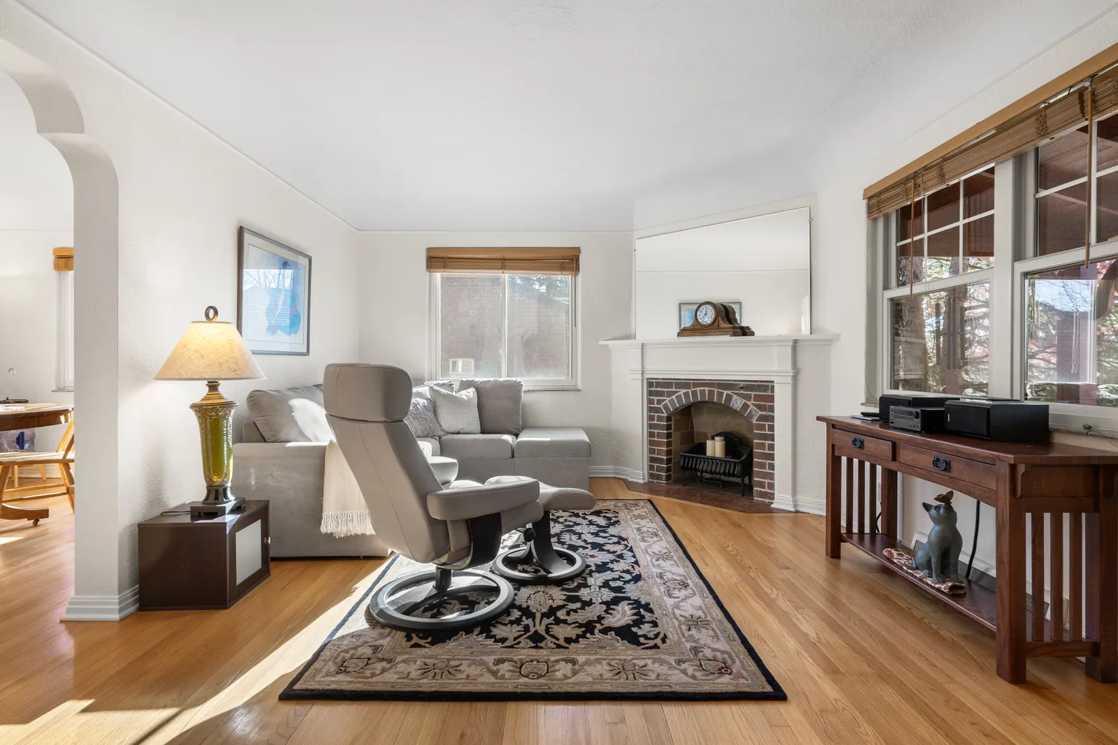 Sunlit living room with corner fireplace and area rug
