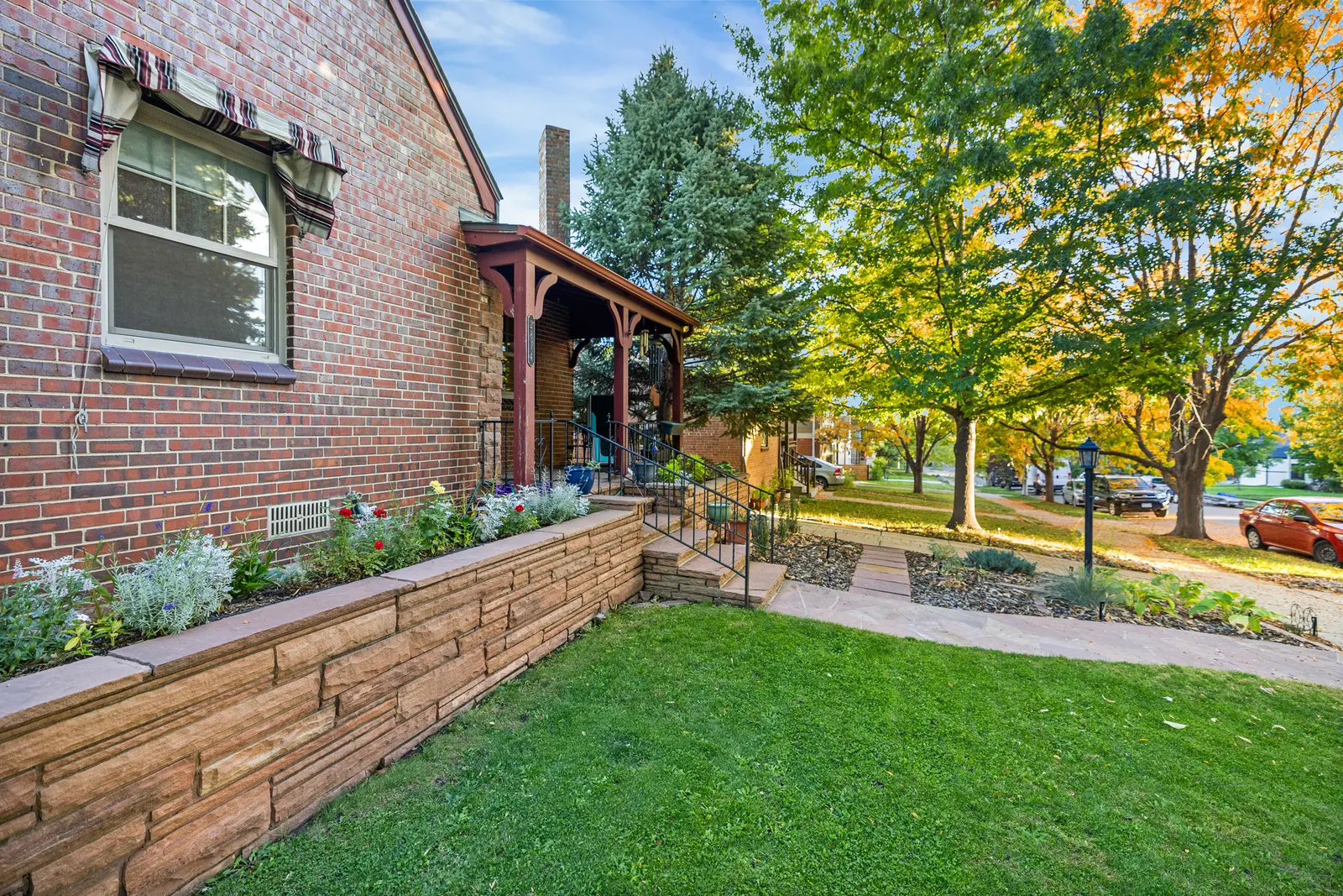 Brick side wall, stone retaining wall and front lawn