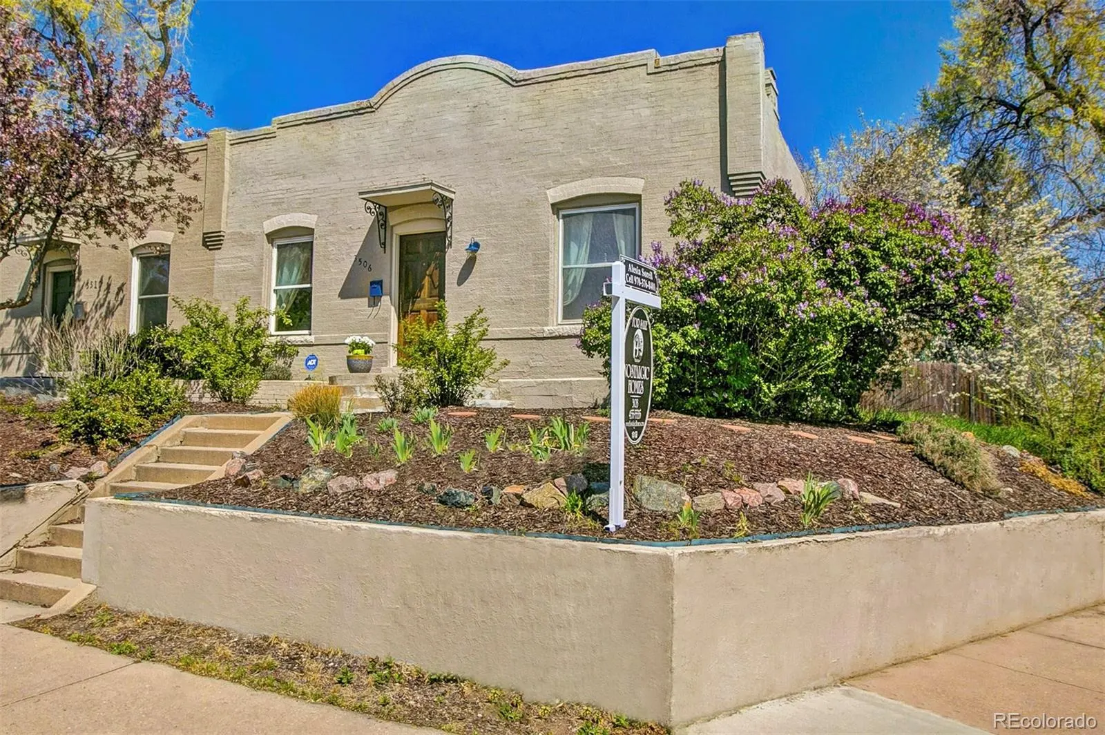 Stucco 1906 half duplex at 3506 Lowell Boulevard with terraced front garden