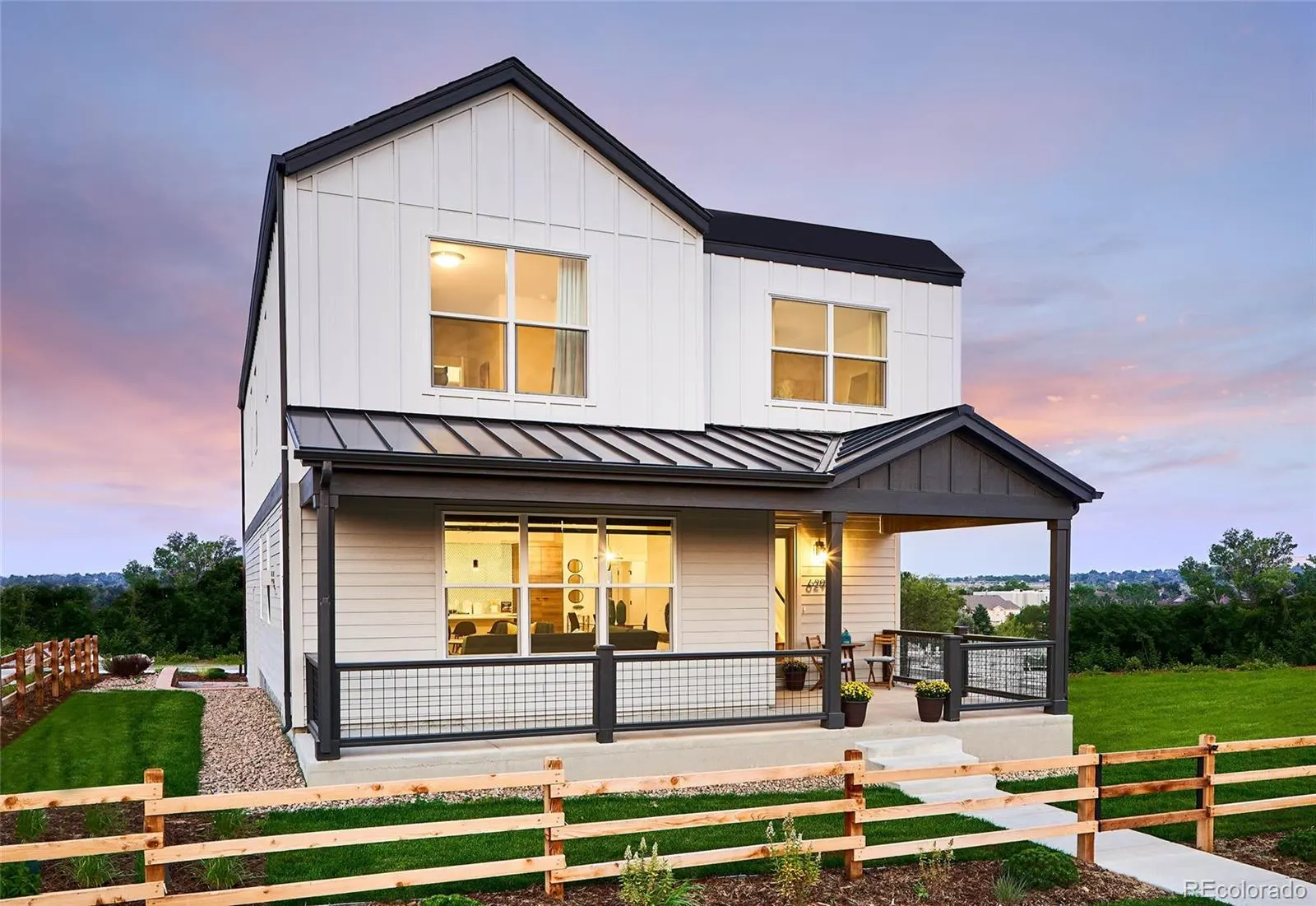 White farmhouse-style model home at Berkley Shores at twilight
