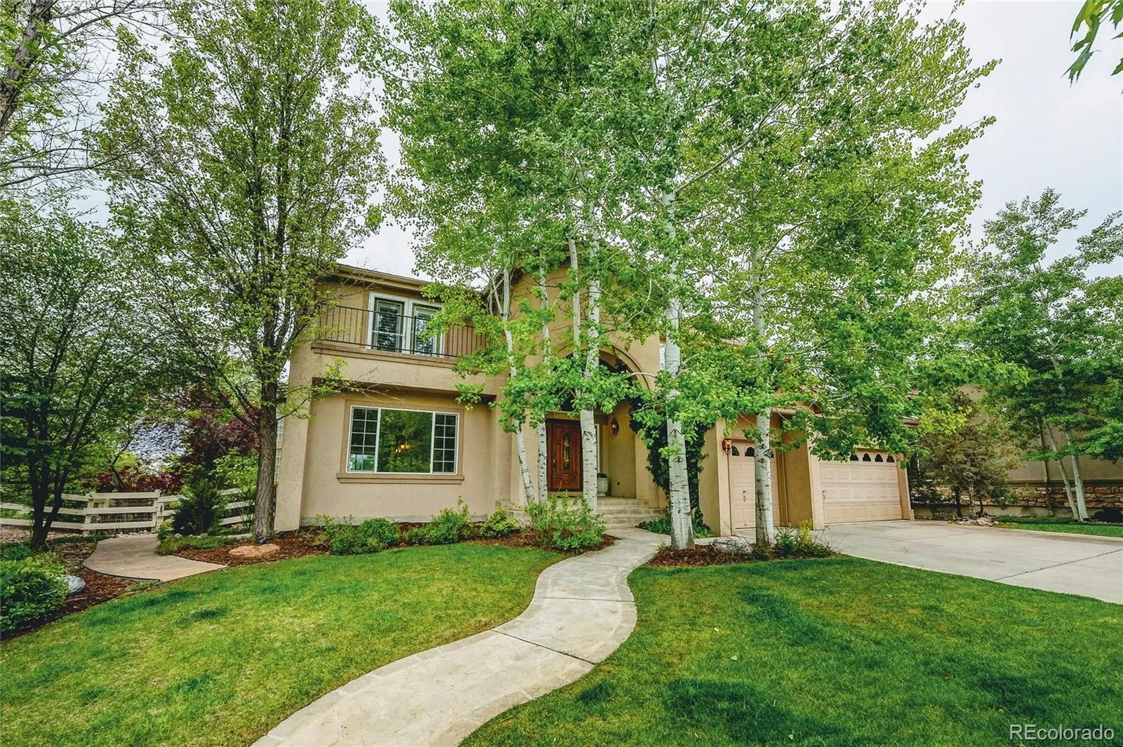 Front of the two-story home at 4380 Crestone Circle with lawn, walkway and mature trees
