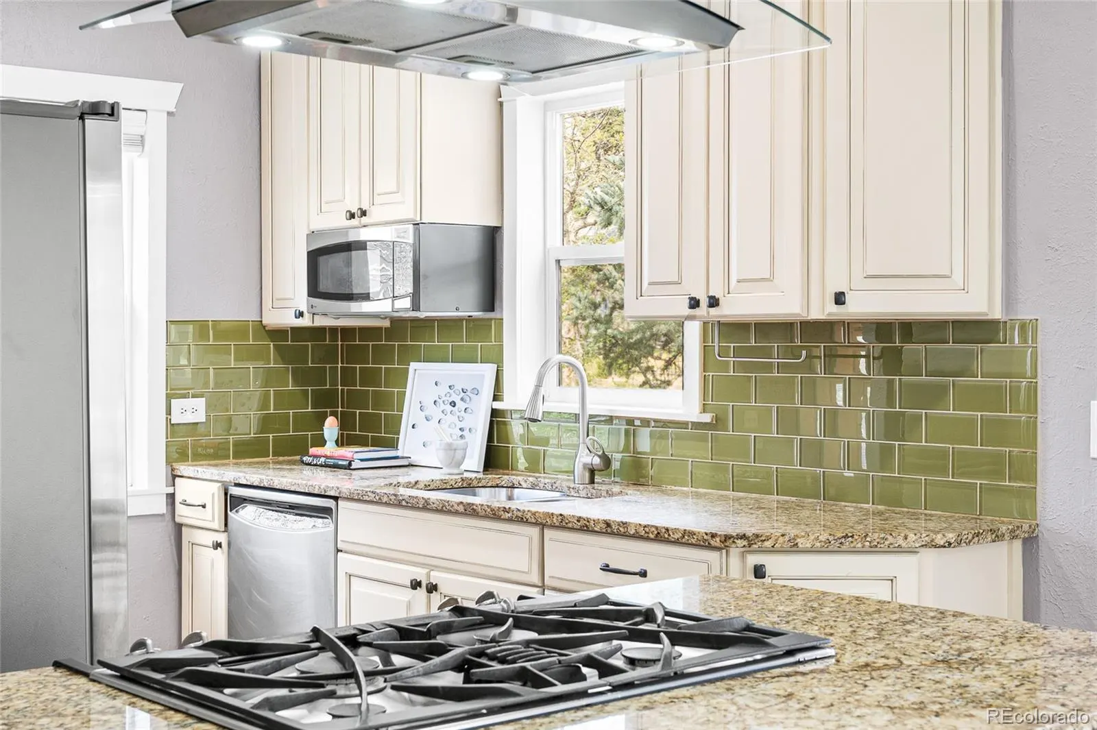 Kitchen counters with green tile backsplash