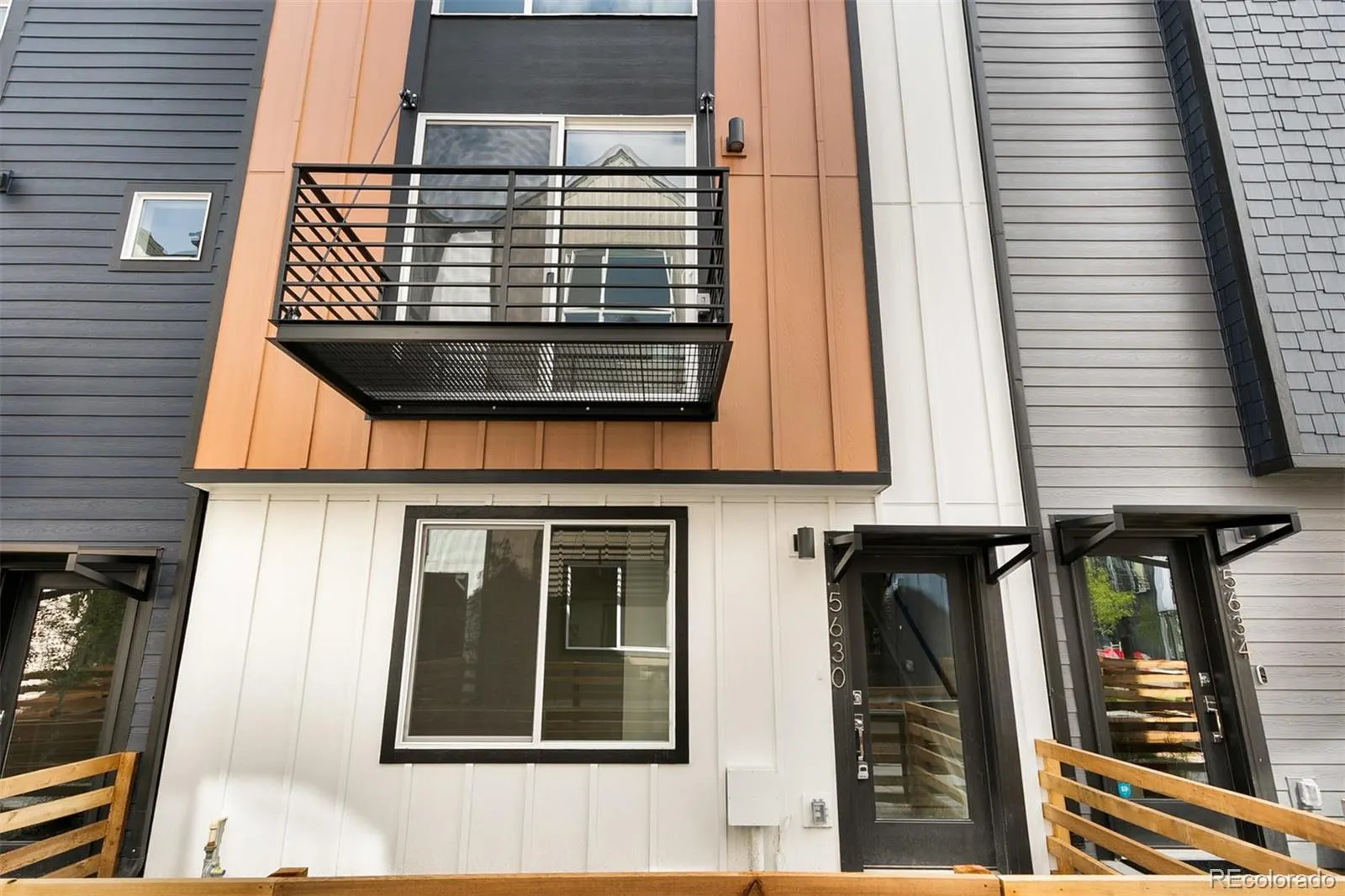 Three-story townhome façade with balcony