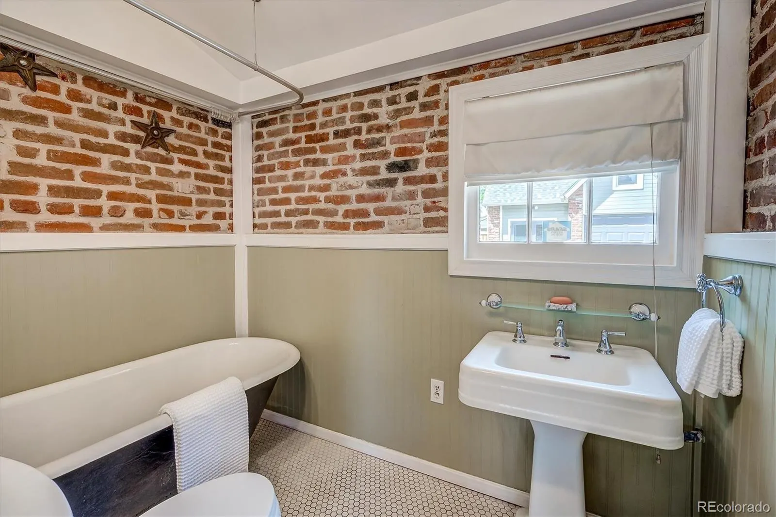 Bath with exposed brick and pedestal sink