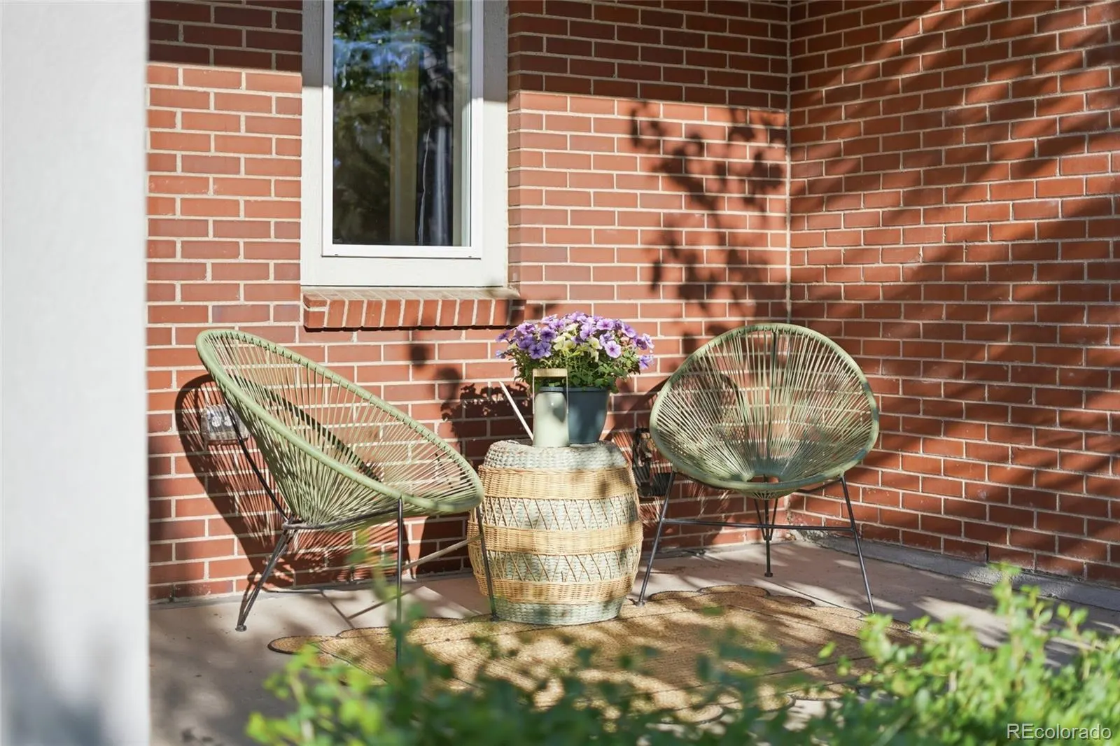 Covered patio with brick façade and seating